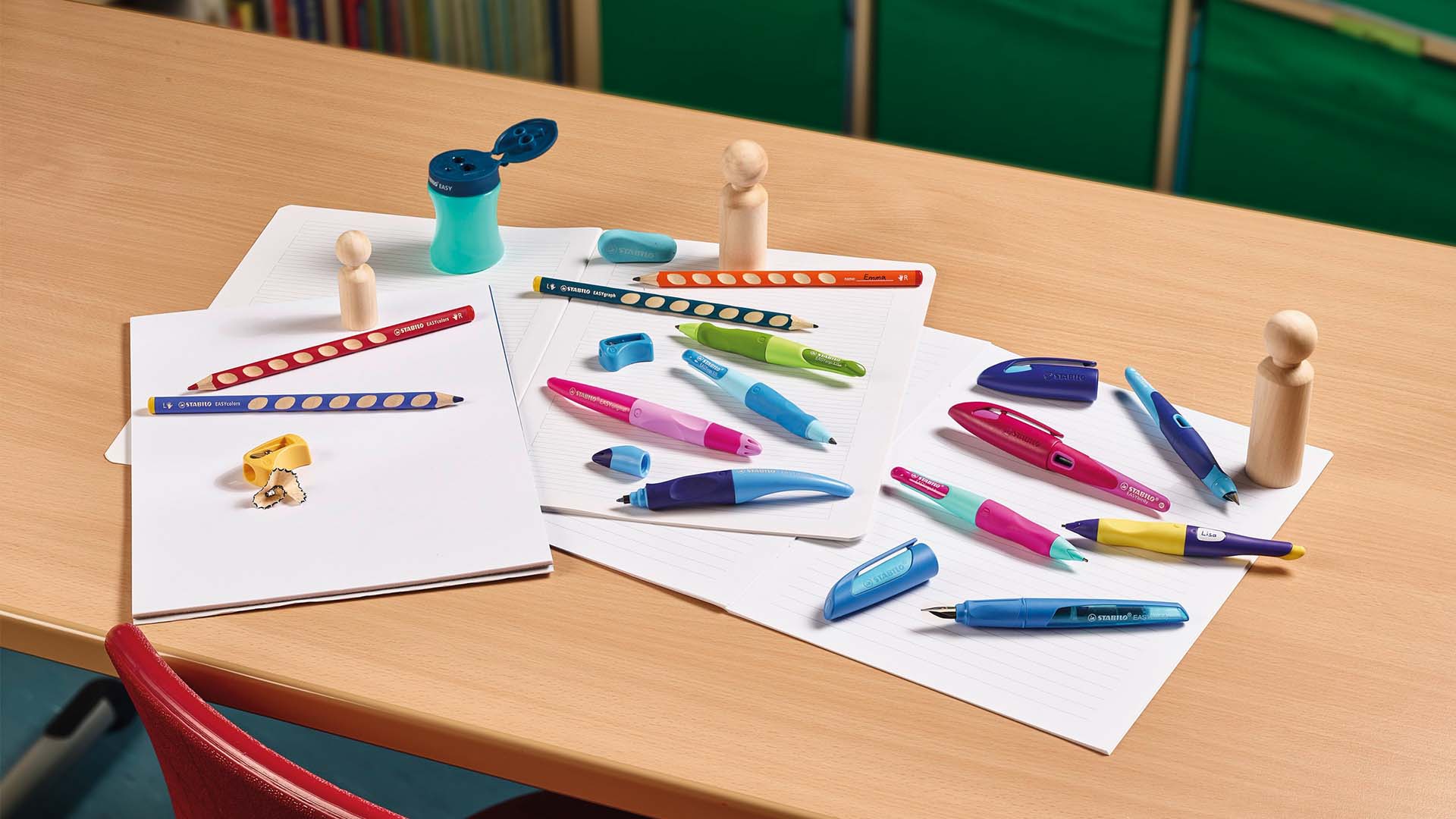 Bunte Schreibutensilien und Figuren auf einem Schreibtisch für ein Schreiblernsystem