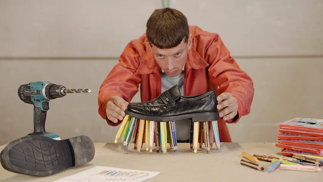 Willem de Haan befestigt STABILO woody Stifte unter die Sohle eines Schuhs.