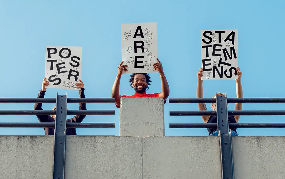 Drei Menschen halten Schilder mit dem Schriftzug 