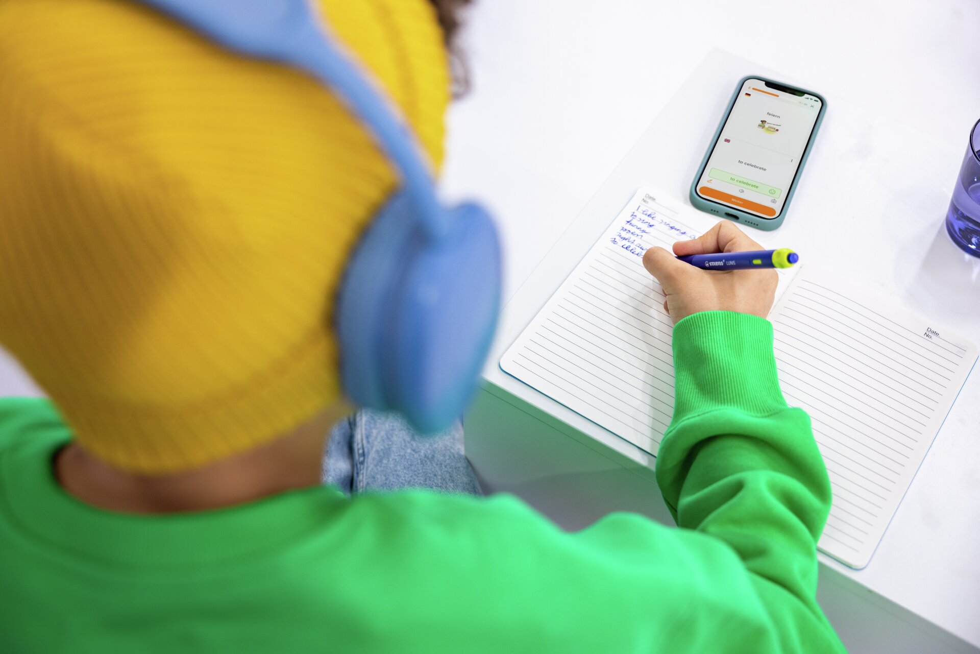 STABILO DigiPen, kopfhörer, notizbuch, telefon, gelbes strickmütze, grünes sweatshirt